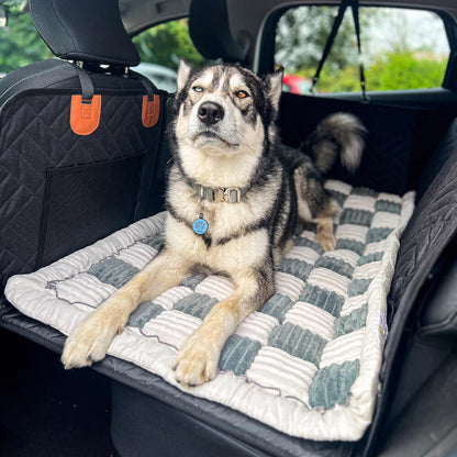 Dog lying comfortably on anti-slip gray plaid car bed mat