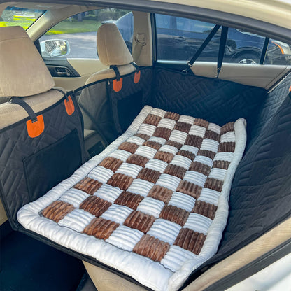 Car back seat with a checkered patterned cover and orange straps.